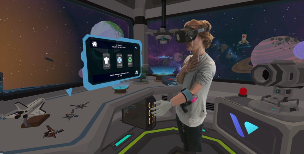 A person standing in front of a computer screen wearing a virtual reality headset and interacting with Virtetic technology.